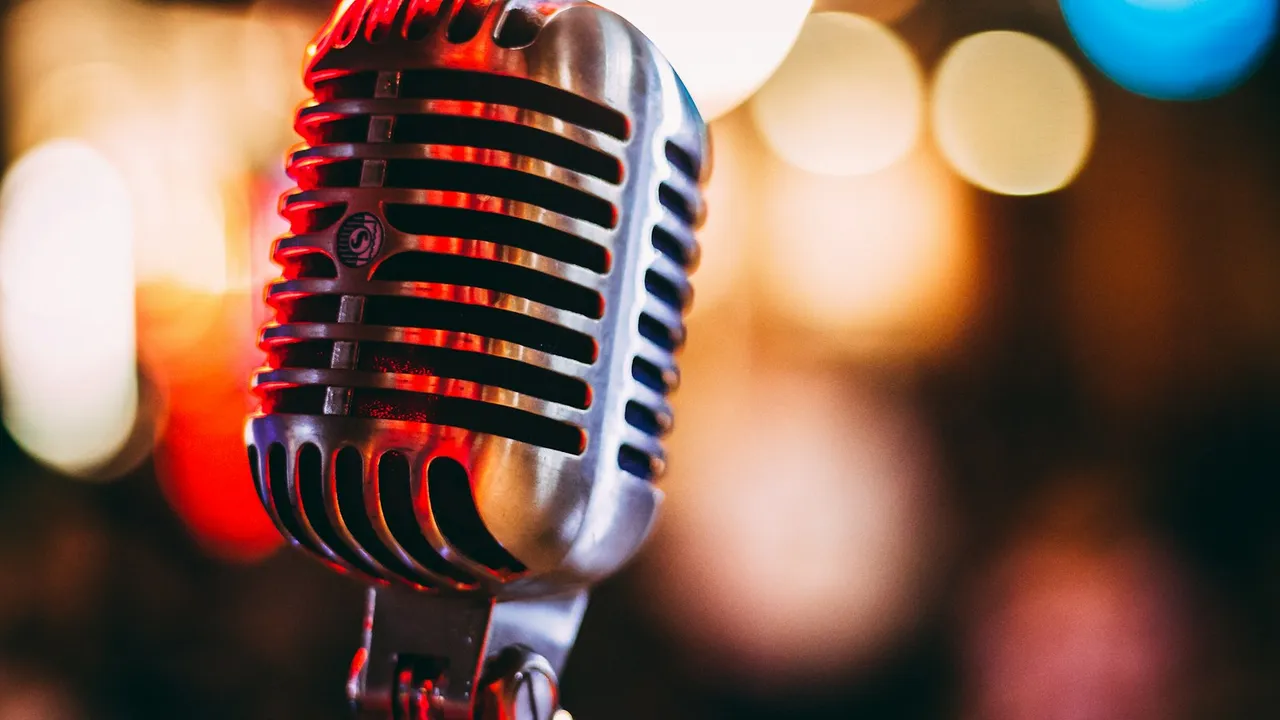 Microfone vintage cromado em um palco com luzes coloridas ao fundo